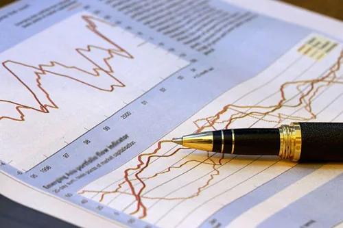 Relatório financeiro impresso com gráfico de evolução e caneta sobre a mesa