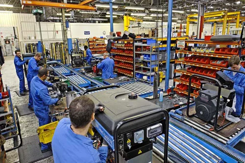 Linha de montagem industrial com operadores em uma esteira de produção